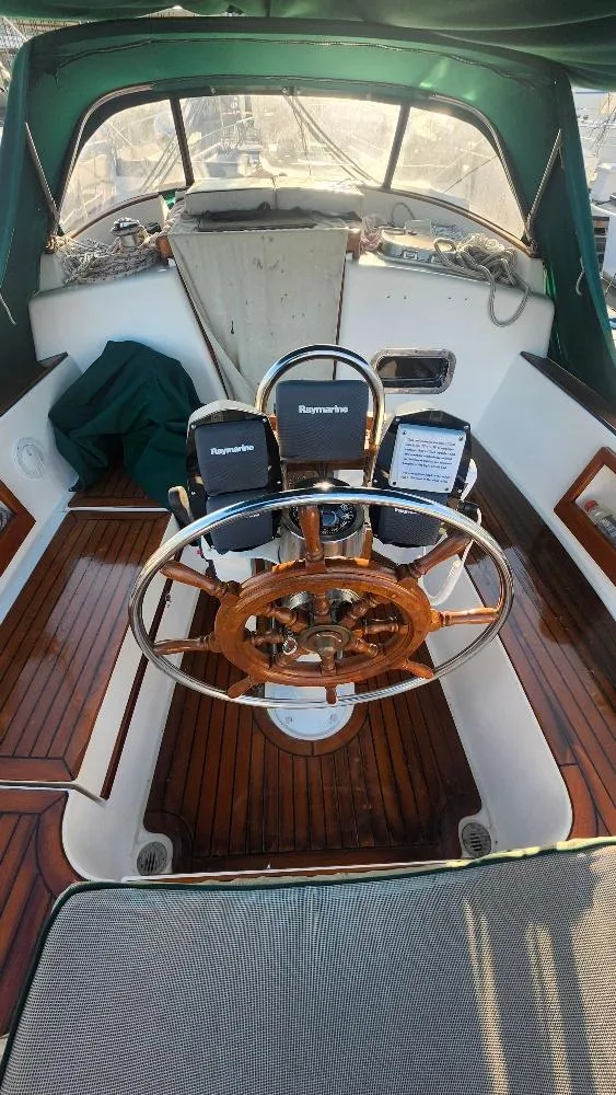 Slide: The Image of 1989 Cabo Rico 34 sailboat cockpit with wooden wheel and navigational instruments. - 27