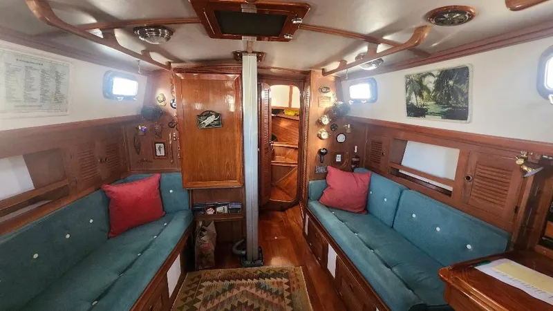 Slide: The Image of 1989 Cabo Rico 34 sailboat interior with wooden finish, teal cushions, and nautical decor. - 3