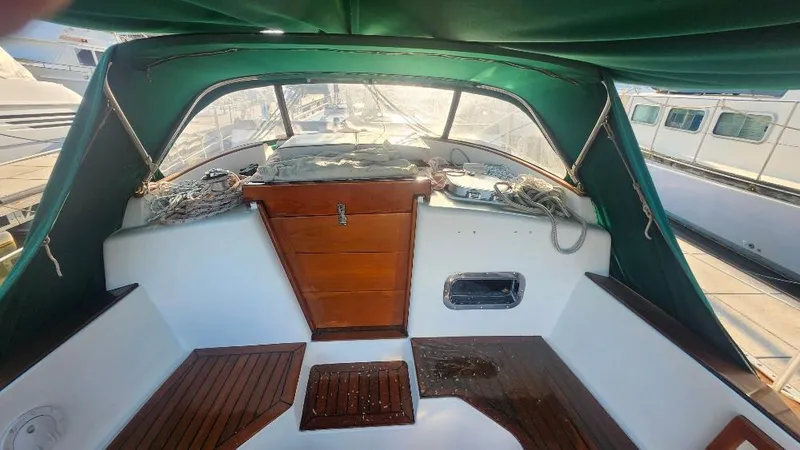 Slide: The Image of 1989 Cabo Rico 34 sailboat cockpit with green canopy and wooden accents. - 30