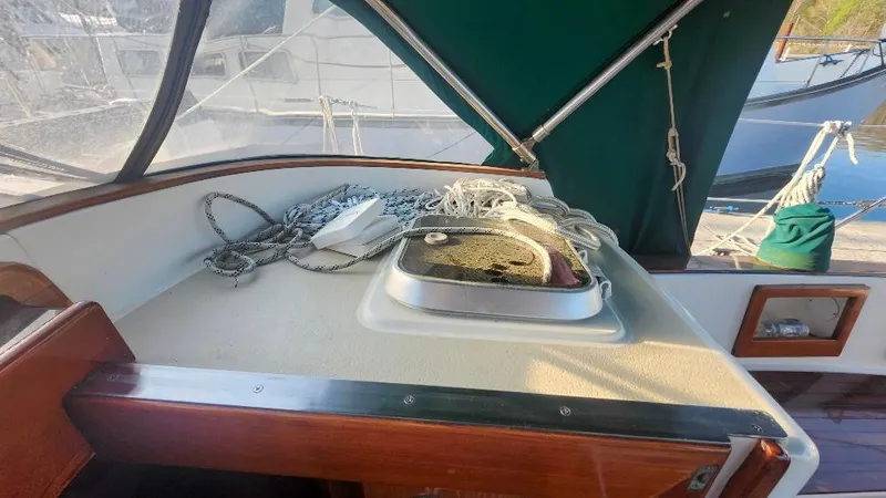 Slide: The Image of 1989 Cabo Rico 34 sailboat cockpit with ropes and hatch, featuring green canopy. - 34