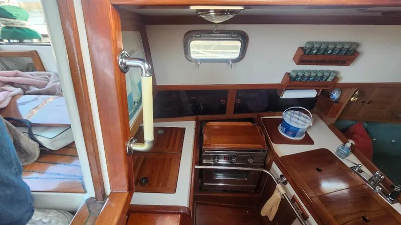 Slide: The Image of 1989 Cabo Rico 34 yacht interior with wooden cabinetry and compact kitchen area. - 35