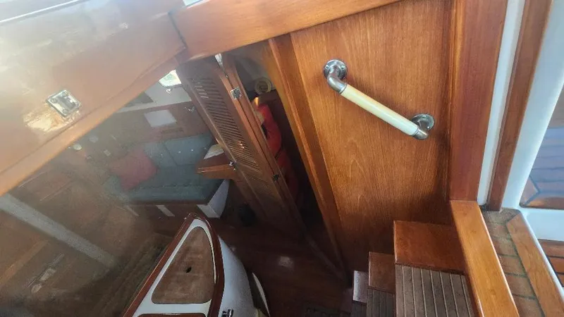 Slide: The Image of Interior view of 1989 Cabo Rico 34 sailboat, featuring wooden stairs and cabin area. - 36