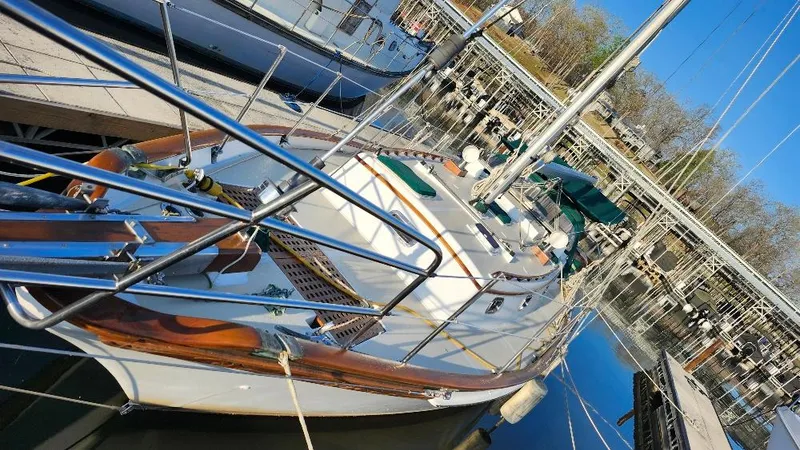 Slide: The Image of 1989 Cabo Rico 34 sailboat docked at marina, featuring polished wood and stainless steel details. - 4