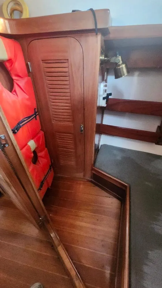 Slide: The Image of Interior of 1989 Cabo Rico 34 sailboat with wooden cabinetry and life jacket. - 48