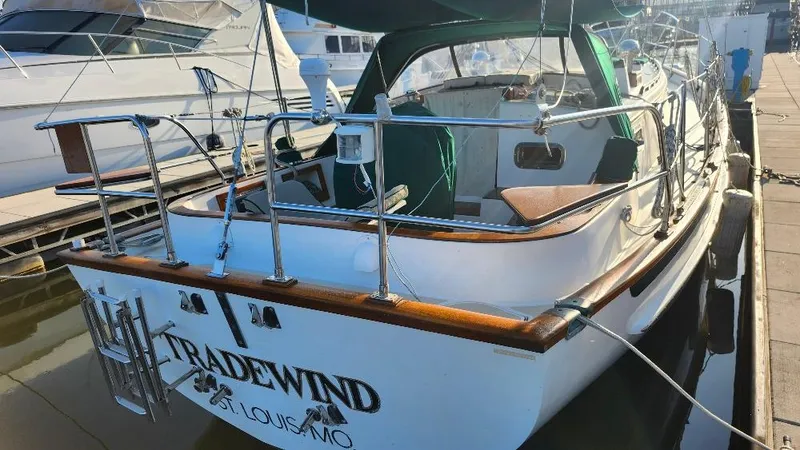 Slide: The Image of 1989 Cabo Rico 34 sailboat docked, featuring wooden accents and "TRADEWIND" name on the stern. - 6
