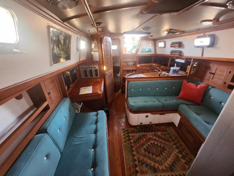 Slide: The Image of Interior of 1989 Cabo Rico 34 sailboat with teal seating and wooden accents. - 9