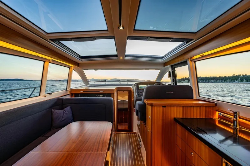 Slide: The Image of Luxurious interior of 2022 Nimbus 405 Coupé yacht with panoramic windows and elegant wood finishes. - 16
