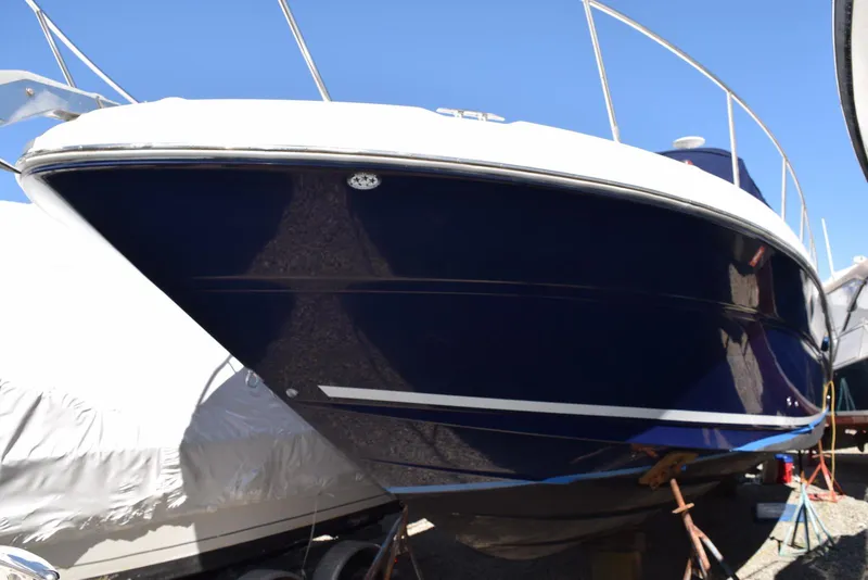 Slide: The Image of 2005 Sea Ray 340 Sundancer boat on dry dock, blue hull, white top, clear sky background. - 1