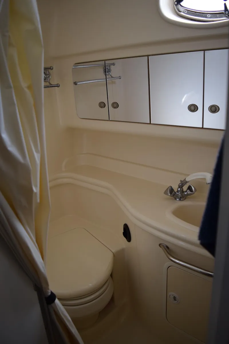 Slide: The Image of 2005 Sea Ray 340 Sundancer bathroom with sink, toilet, and storage cabinets. - 13