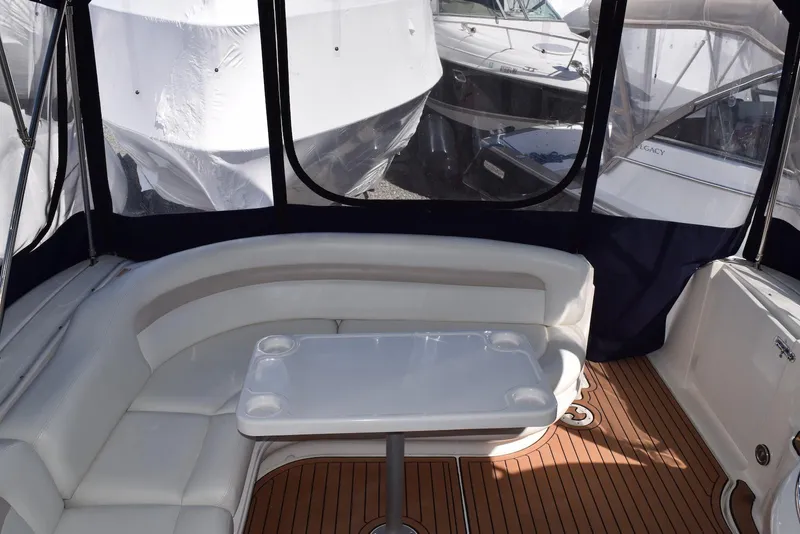 Slide: The Image of 2005 Sea Ray 340 Sundancer cockpit with white seating and table, surrounded by boats. - 19