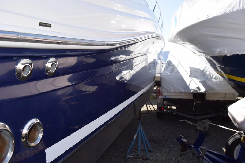 Slide: The Image of 2005 Sea Ray 340 Sundancer boat, blue and white hull, docked on land. - 29