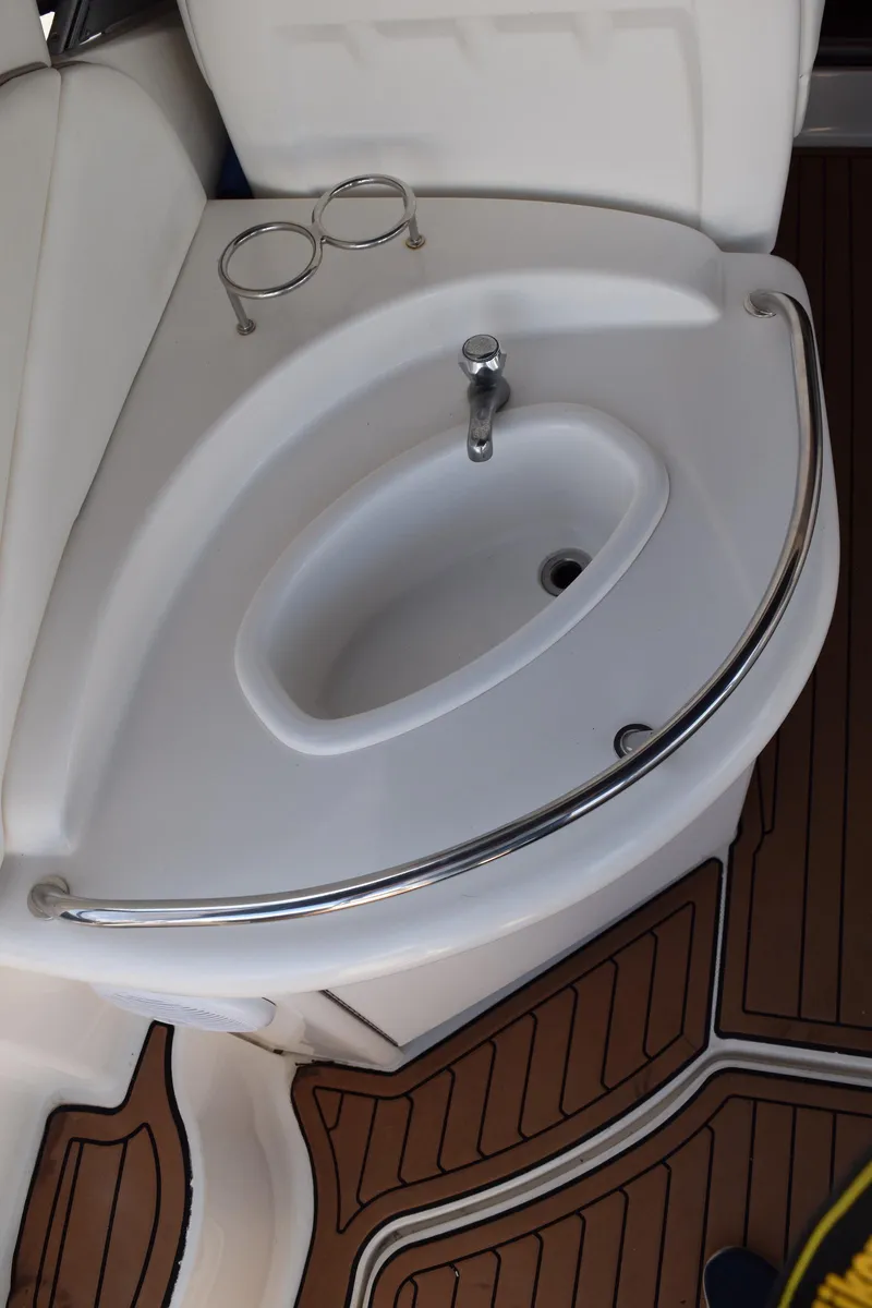 Slide: The Image of 2005 Sea Ray 340 Sundancer boat sink with wooden flooring and cup holders. - 35