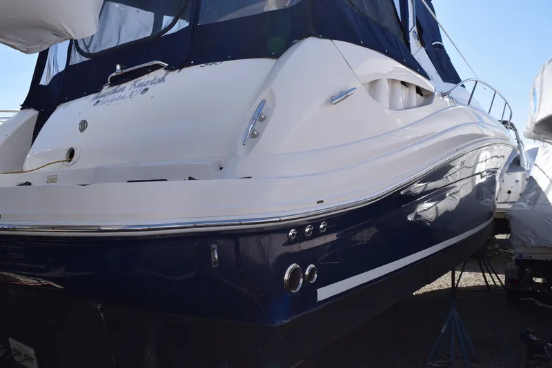 Slide: The Image of 2005 Sea Ray 340 Sundancer boat, white and blue exterior, docked on land. - 44