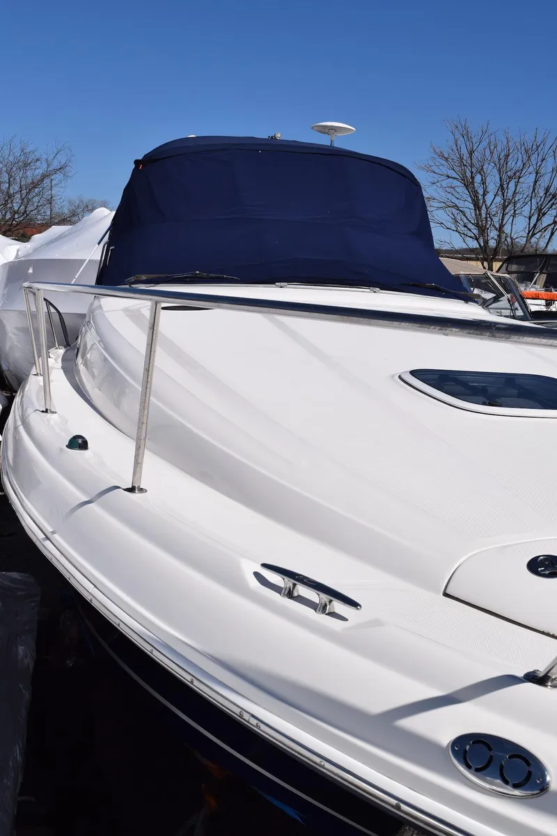 Slide: The Image of 2005 Sea Ray 340 Sundancer boat with blue canopy, docked under clear sky. - 7