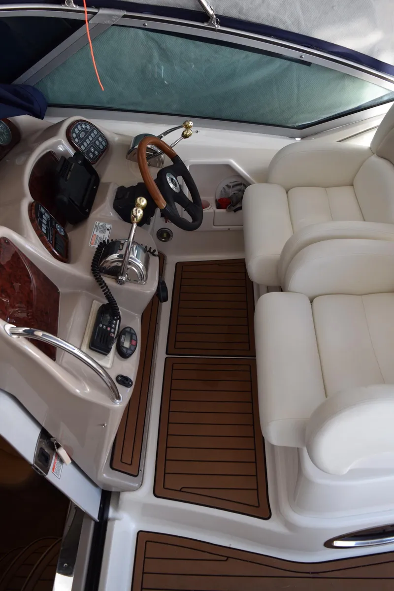 Slide: The Image of 2005 Sea Ray 340 Sundancer cockpit with dual seats and wooden flooring. - 9