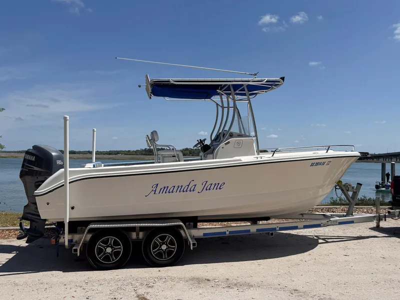 Slide: The Image of 2012 Edgewater 205CC boat named "Amanda Jane" on trailer by the water. - 1