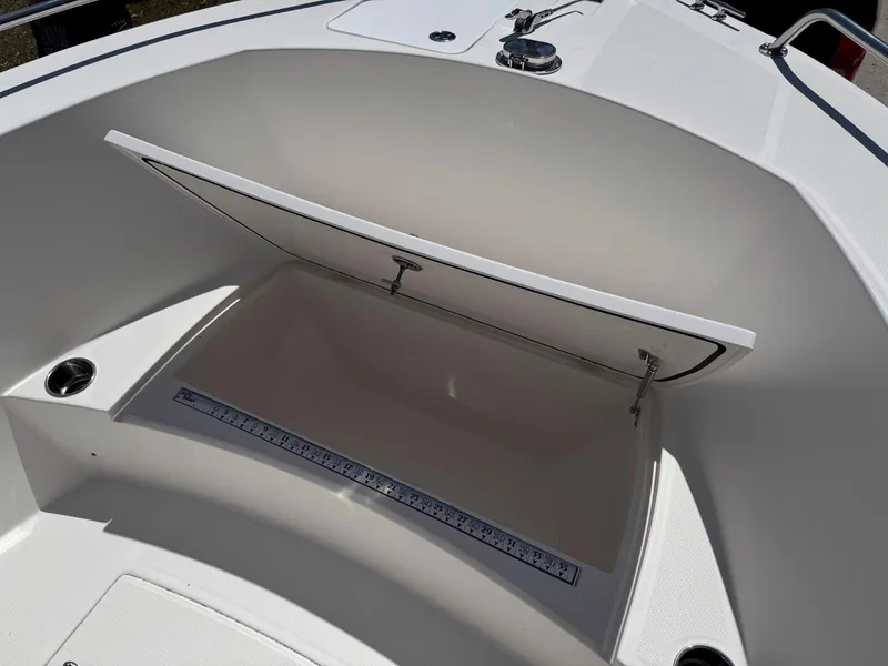 Slide: The Image of Open storage compartment on 2012 Edgewater 205CC boat, featuring a built-in measuring ruler. - 11