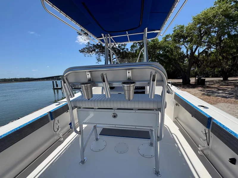 Slide: The Image of 2012 Edgewater 205CC boat with blue canopy, docked by a scenic waterfront. - 14