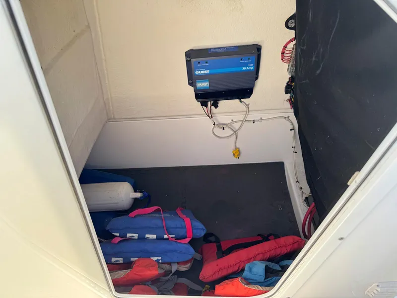 Slide: The Image of Storage compartment in a 2012 Edgewater 205CC boat with life jackets and a mounted device. - 15