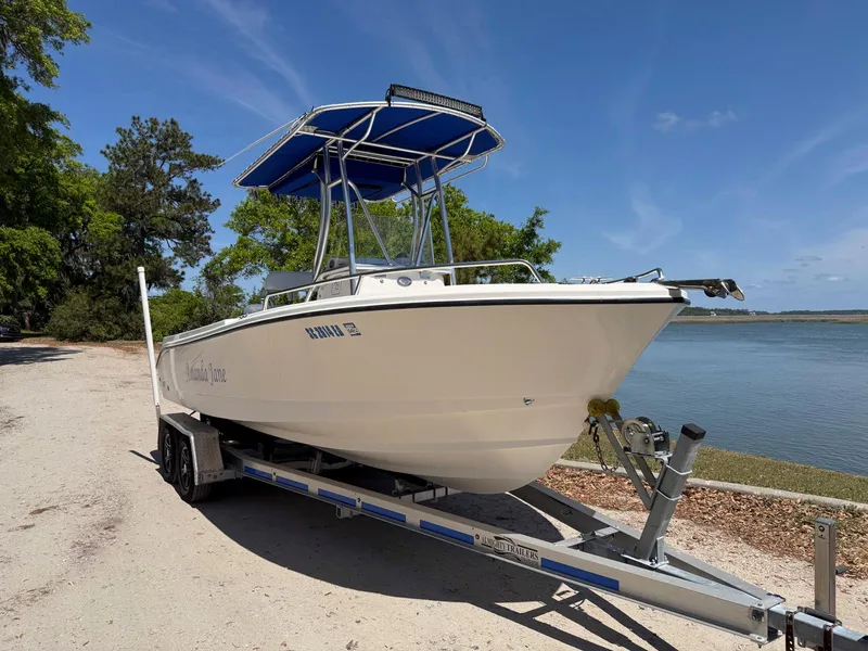 Slide: The Image of 2012 Edgewater 205CC boat on trailer by a lake, under clear blue sky. - 3