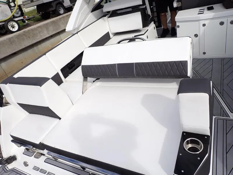 Slide: The Image of 2023 Monterey 385 Super Sport boat interior with white and black seating and cup holder. - 17