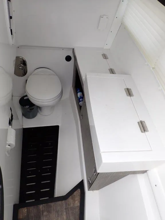 Slide: The Image of 2023 Monterey 385 Super Sport boat bathroom with toilet and storage cabinet. - 19