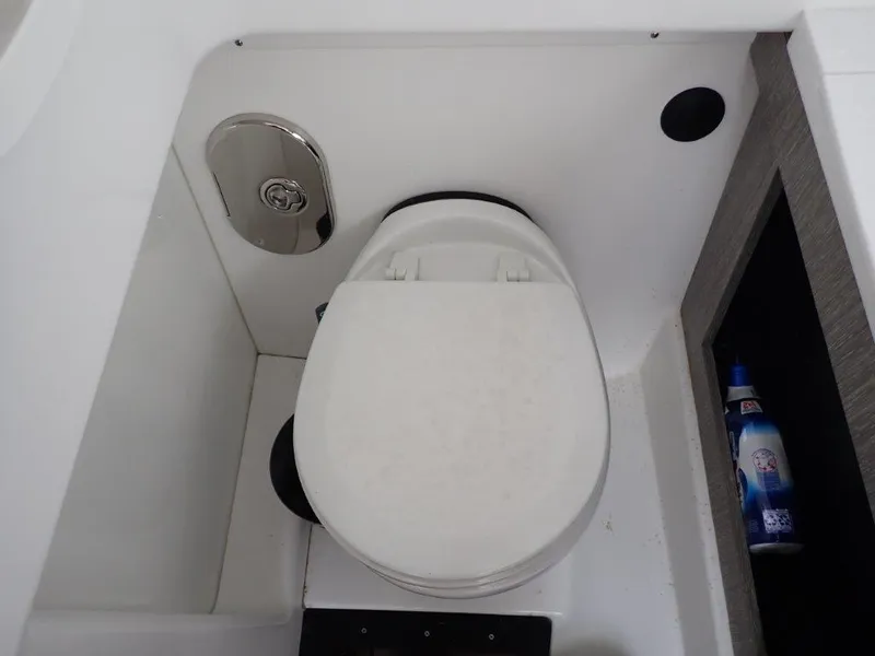 Slide: The Image of 2023 Monterey 385 Super Sport boat toilet with storage compartment and cleaning supplies. - 21