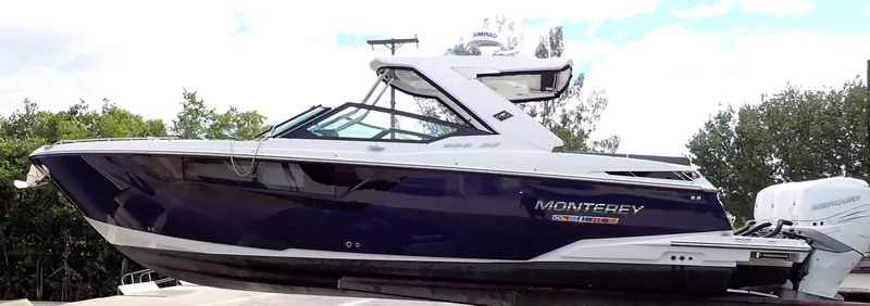 Slide: The Image of 2023 Monterey 385 Super Sport boat with sleek design, docked outdoors. - 29