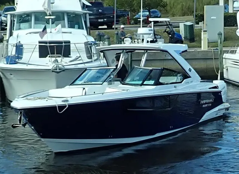 Slide: The Image of 2023 Monterey 385 Super Sport boat docked in a marina, featuring sleek design and modern amenities. - 30