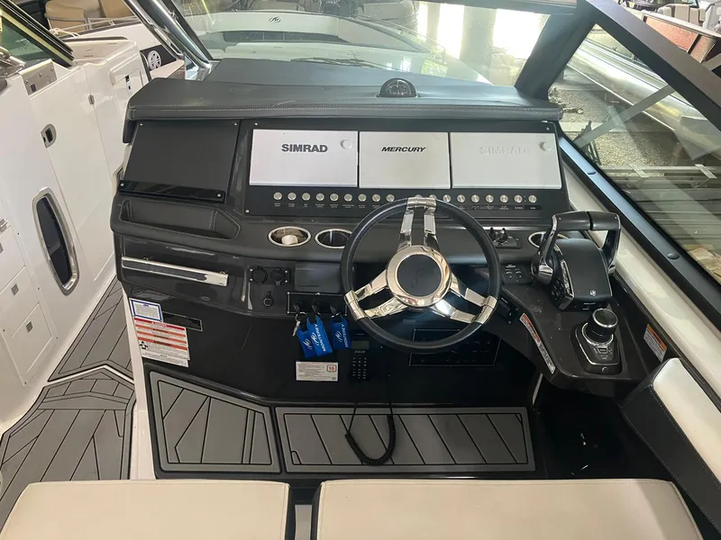 Slide: The Image of 2023 Monterey 385 Super Sport boat dashboard with steering wheel and navigation controls. - 32