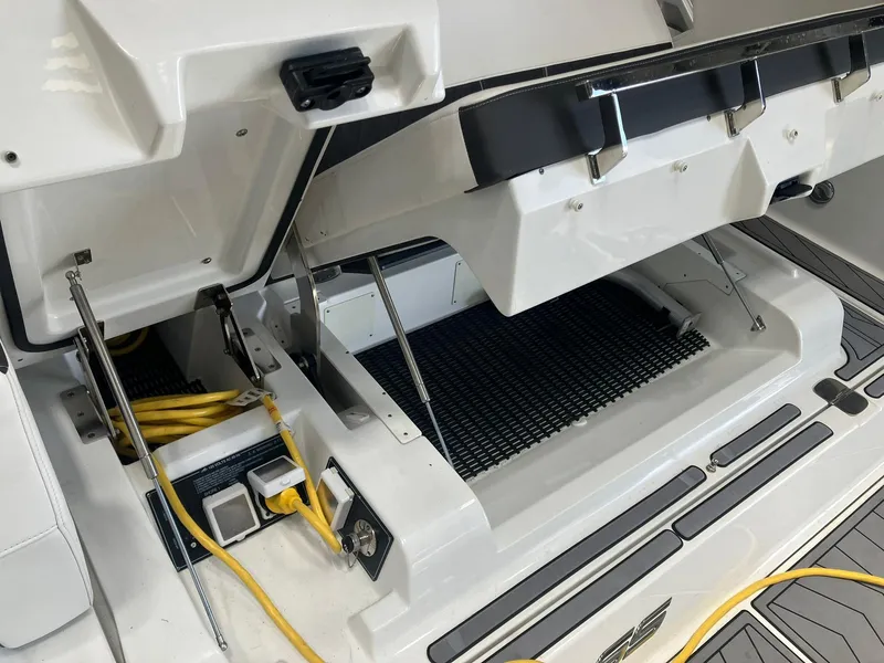 Slide: The Image of 2023 Monterey 385 Super Sport boat storage compartment with open hatch and yellow cables. - 39