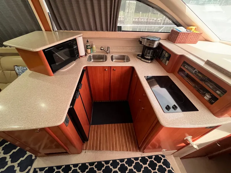 Slide: The Image of Compact kitchen in a 2003 Meridian 381 Sedan yacht with modern appliances and wood cabinetry. - 15