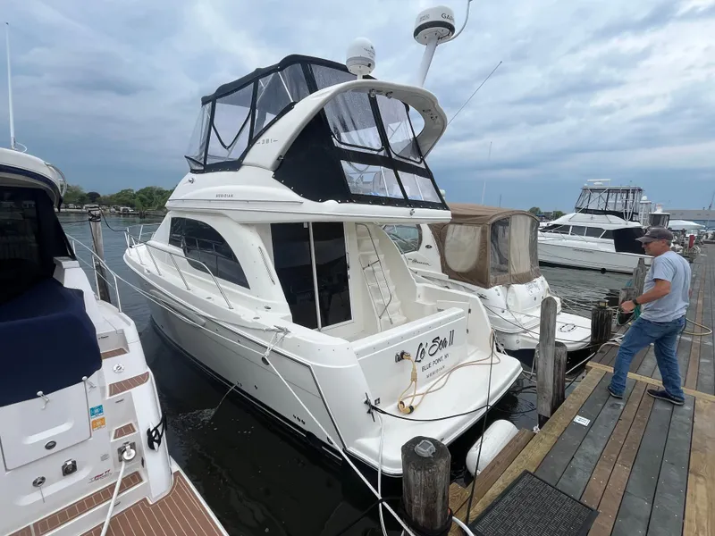 Slide: The Image of 2003 Meridian 381 Sedan yacht docked at marina, featuring sleek design and spacious upper deck. - 21