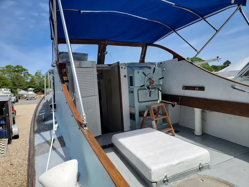 Slide: The Image of 1971 Dyer 29 Classic Downeast Bass Boat with blue canopy and wooden accents. - 10