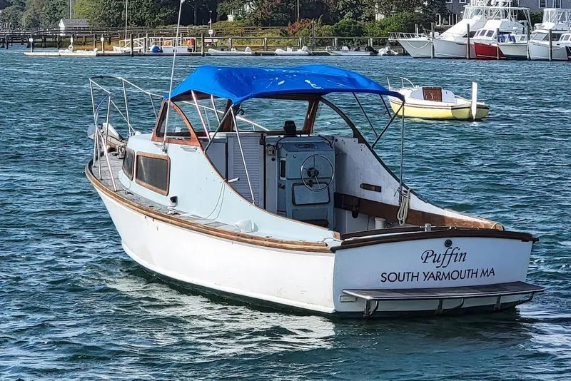 Slide: The Image of 1971 Dyer 29 classic downeast bass boat with blue canopy on water, South Yarmouth, MA. - 5