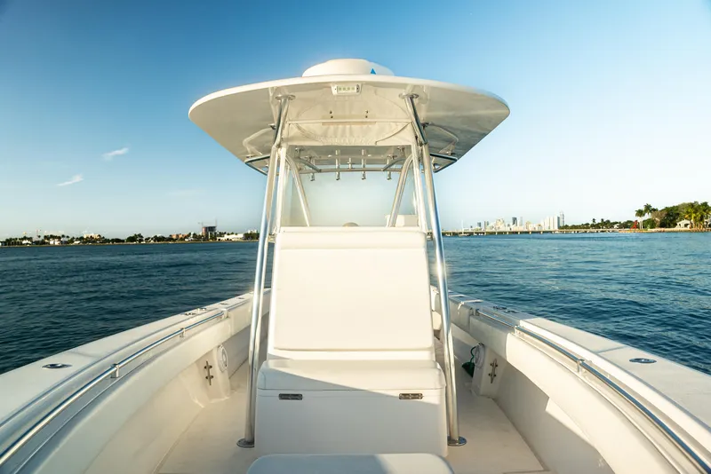 Slide: The Image of 2015 Contender 32 ST boat with rod holders, on a sunny day by the water. - 2