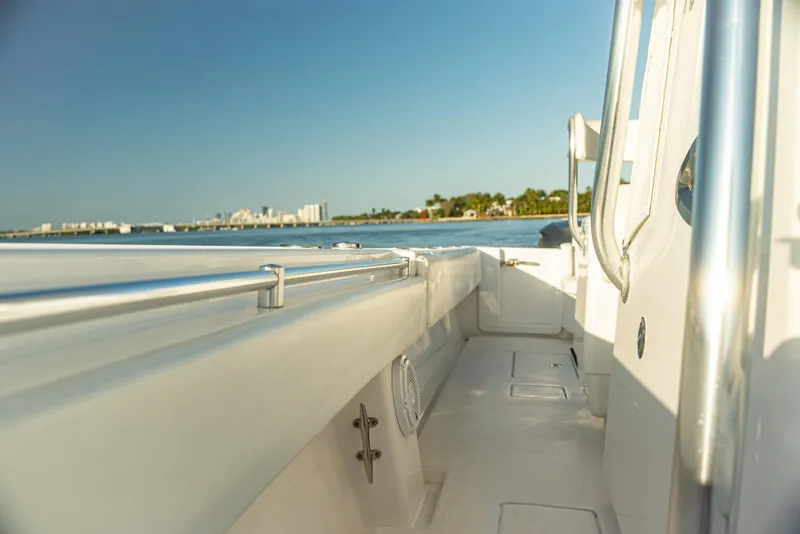 Slide: The Image of 2015 Contender 32 ST boat on calm water, showcasing sleek design and spacious deck. - 7