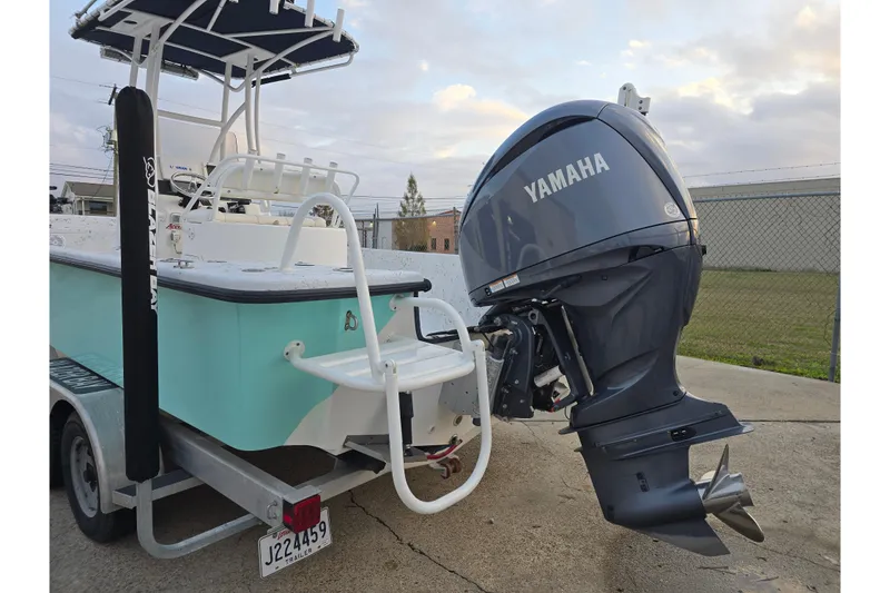 Slide: The Image of Blazer Bay 2400 boat with Yamaha outboard motor, parked on a trailer, 2012 model. - 14