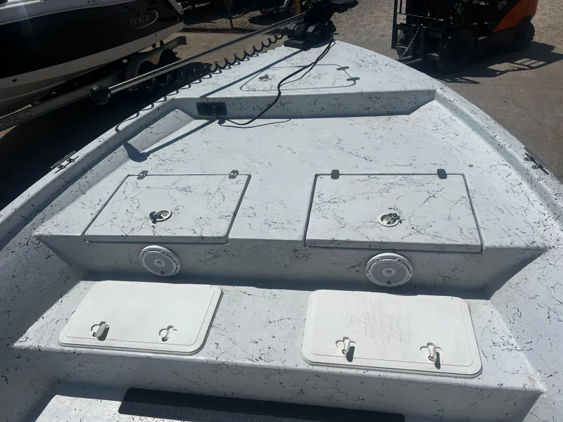 Slide: The Image of 2012 Blazer Bay 2400 boat on trailer, parked outdoors near a warehouse. - 3