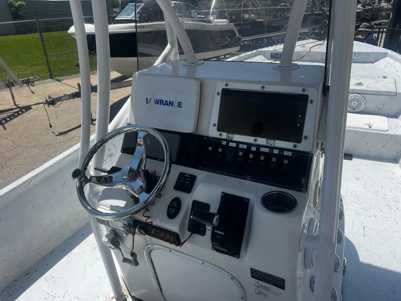 Slide: The Image of 2012 Blazer Bay 2400 boat interior with white seating and steering wheel at sunset. - 5