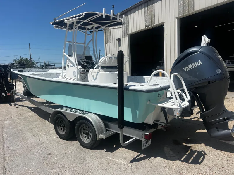 Slide: The Image of 2012 Blazer Bay 2400 boat with trolling motor, parked outside a garage. - 7