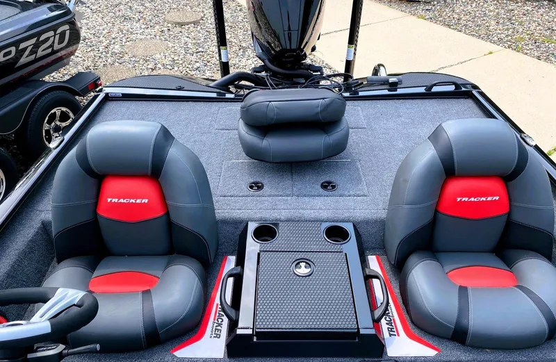 Slide: The Image of 2025 Tracker Savage 215 boat interior with gray and red seats, cup holders, and steering wheel. - 5