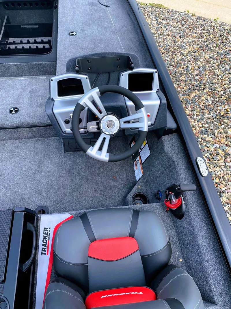 Slide: The Image of 2025 Tracker Savage 215 boat interior with steering wheel and seating. - 7