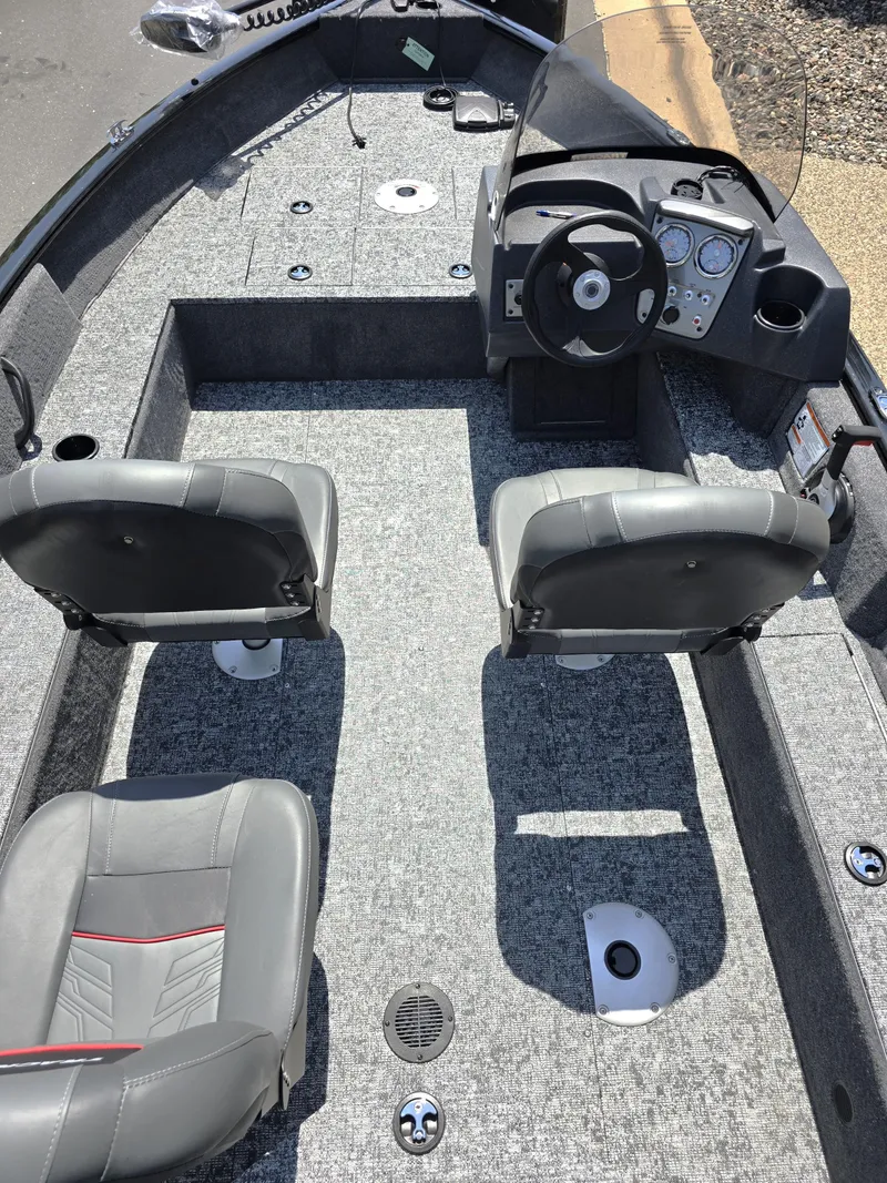 Slide: The Image of 2025 Tracker Pro Guide V-16 SC boat interior with gray seating and modern dashboard. - 3