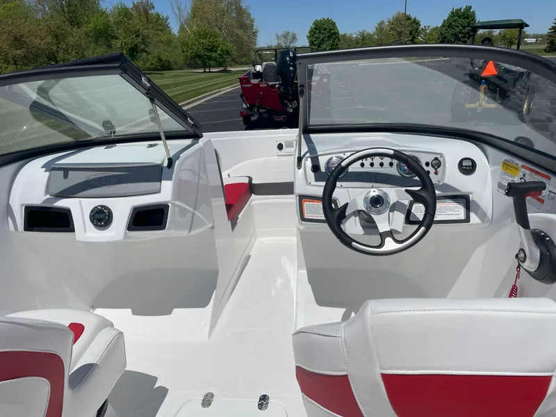 Slide: The Image of 2025 Tahoe 185 S boat interior with steering wheel and red-accented seating. - 2