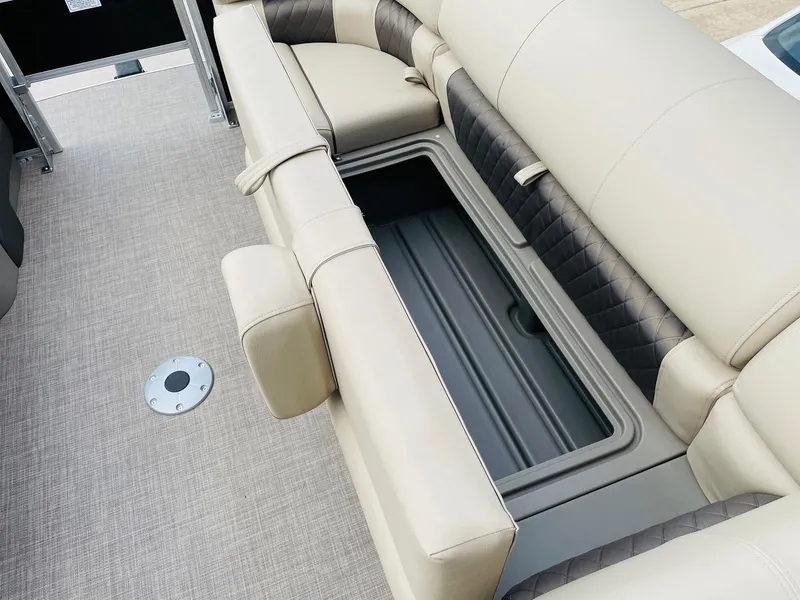 Slide: The Image of 2025 Sun Tracker SportFish 22 DLX boat interior with open storage compartment and beige seating. - 17