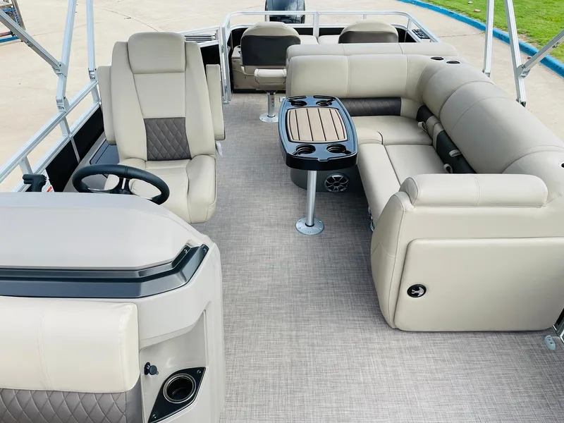 Slide: The Image of 2025 Sun Tracker SportFish 22 DLX pontoon boat interior with beige seating and table. - 19