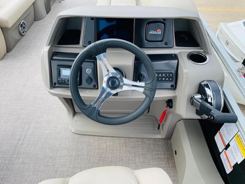 Slide: The Image of 2025 Sun Tracker SportFish 22 DLX dashboard with steering wheel and control panel. - 22
