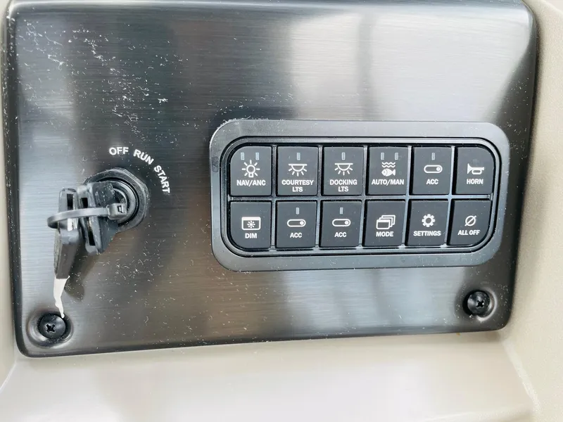 Slide: The Image of Control panel of 2025 Sun Tracker SportFish 22 DLX boat with various switches and ignition. - 25