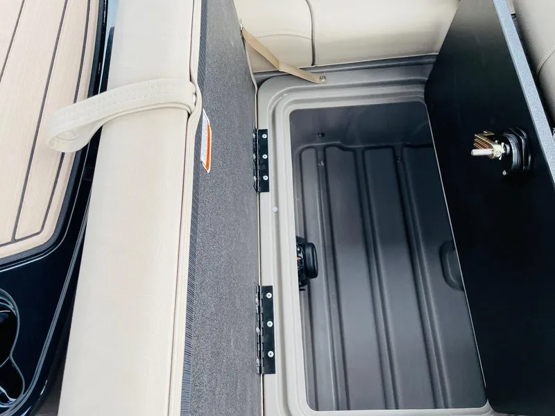Slide: The Image of 2025 Sun Tracker SportFish 22 DLX storage compartment with open lid, showcasing interior space. - 29